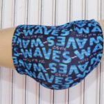 Dark blue WAVES boxer briefs with light blue printed branding, displayed on a mannequin against a white wooden background.