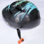 Black ventilated sports helmet with blue and yellow streaks, multiple airflow holes, and an orange buckle on the adjustable black strap, displayed on a white surface.