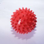 Red spiky massage ball with textured surface for deep tissue relief, placed on a white background.
