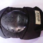 Heavy-duty knee pad with a hard plastic shell and adjustable straps, providing impact protection for sports and work safety.