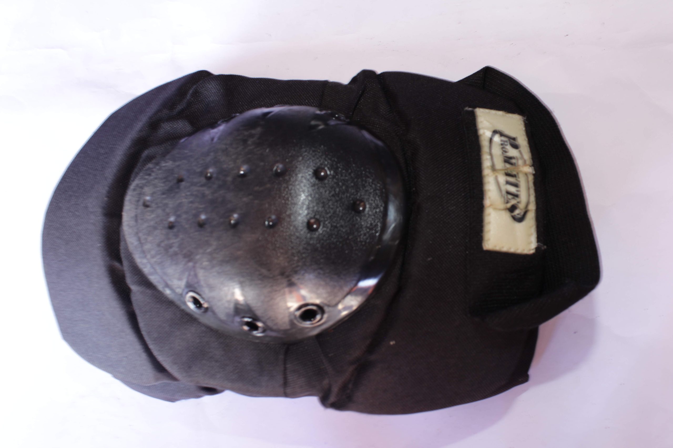 Heavy-duty knee pad with a hard plastic shell and adjustable straps, providing impact protection for sports and work safety.