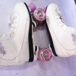 White Roller Star 600 roller skates with pink wheels, black soles, and white laces, featuring purple brand text and a star graphic on the side.