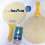 Pro Kadima Paddle & Tennis Ball Set including two wooden paddles, a blue ball, and a Kennex tennis ball canister, displayed on a white surface.