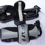 A pair of GAIT by DEBEER Elbow Pads with durable padding and adjustable straps, designed for impact protection in contact sports like lacrosse and hockey.