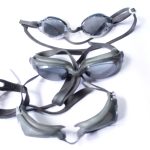 Three pairs of anti-fog swimming goggles with dark lenses and black straps, designed for UV protection and comfort.