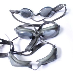 Three pairs of anti-fog swimming goggles with dark lenses and black straps, designed for UV protection and comfort.